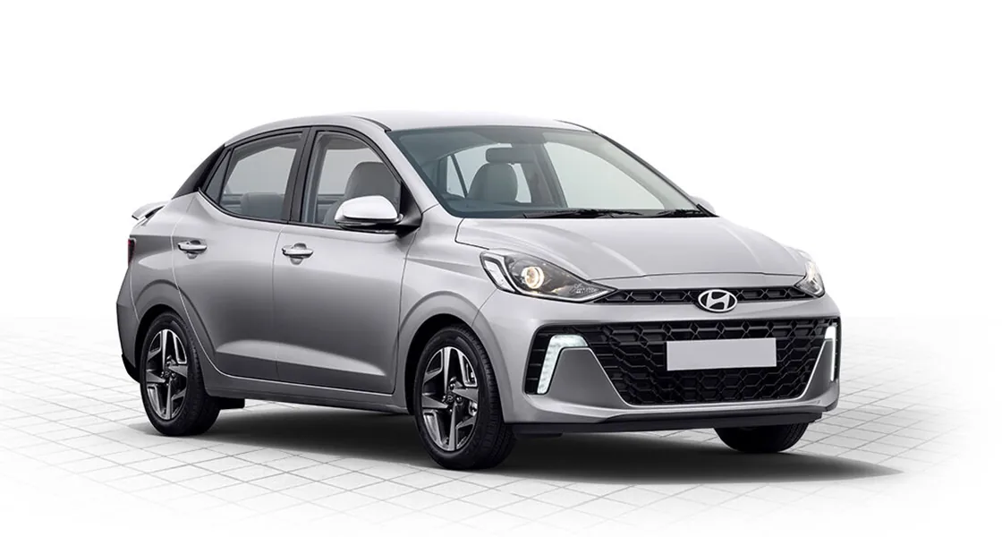 2026 Hyundai Grand i10 Sedan front three-quarter view, chrome grille