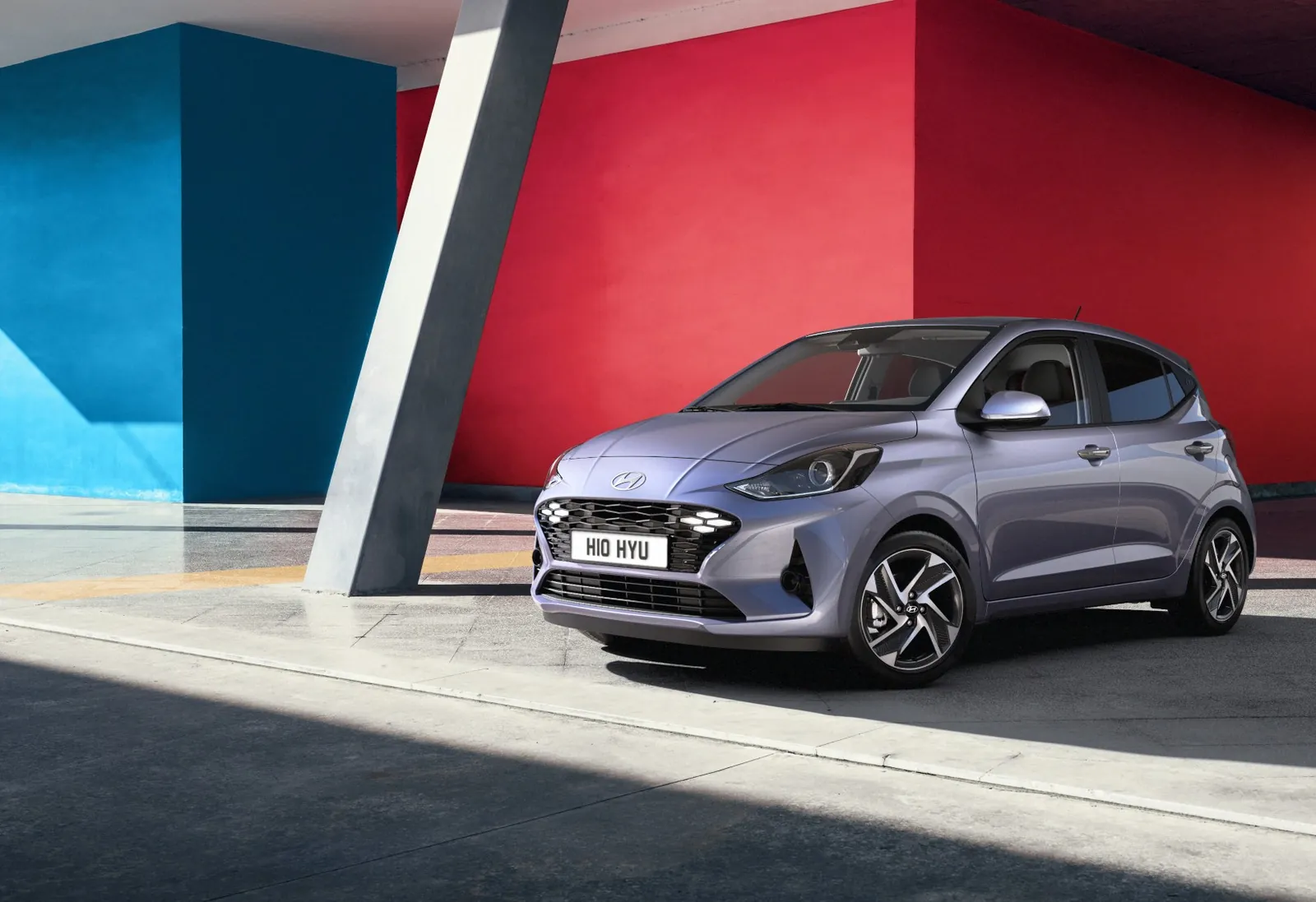Neue Hyundai i10 2026 unter einer bunten Architektur geparkt