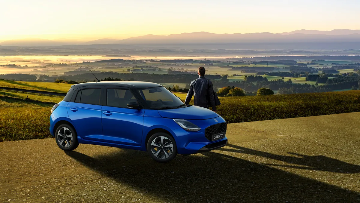 Suzuki Swift 2026 in Blau vor einer ländlichen Kulisse
