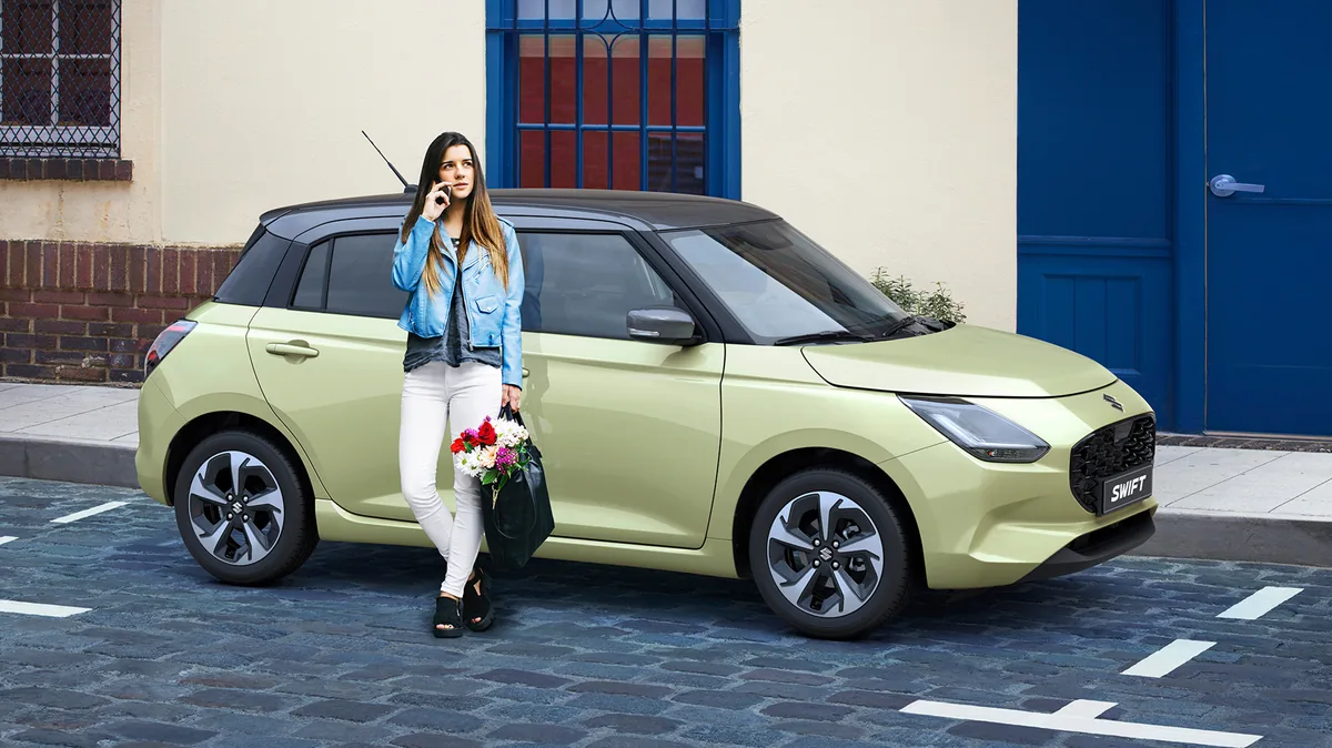 Suzuki Swift 2026 in Grün in der Stadt mit schwarzem Dach