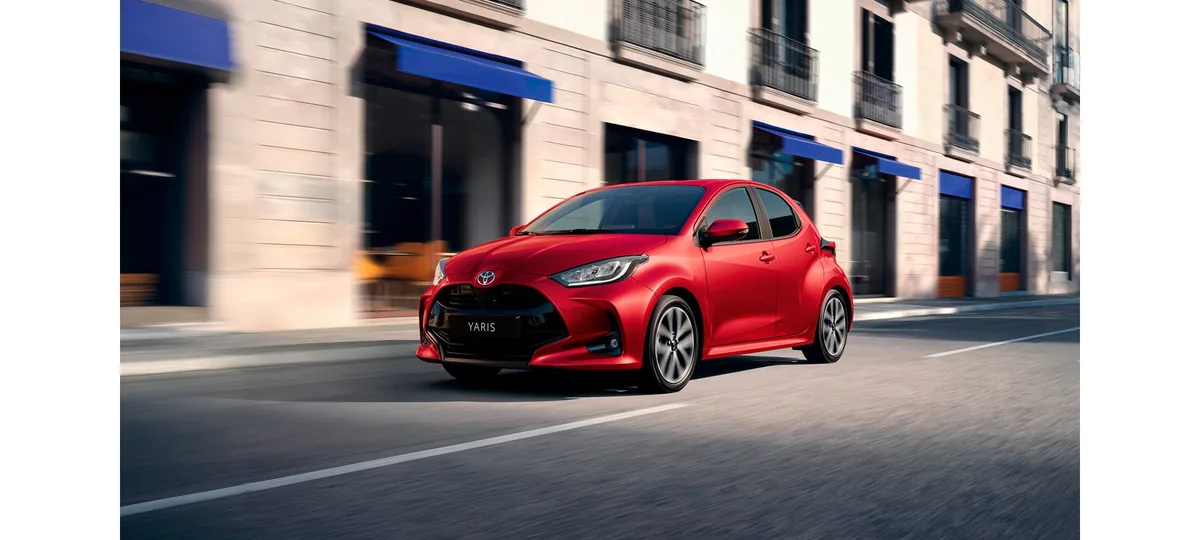 Red 2026 Toyota Yaris Hybrid in motion